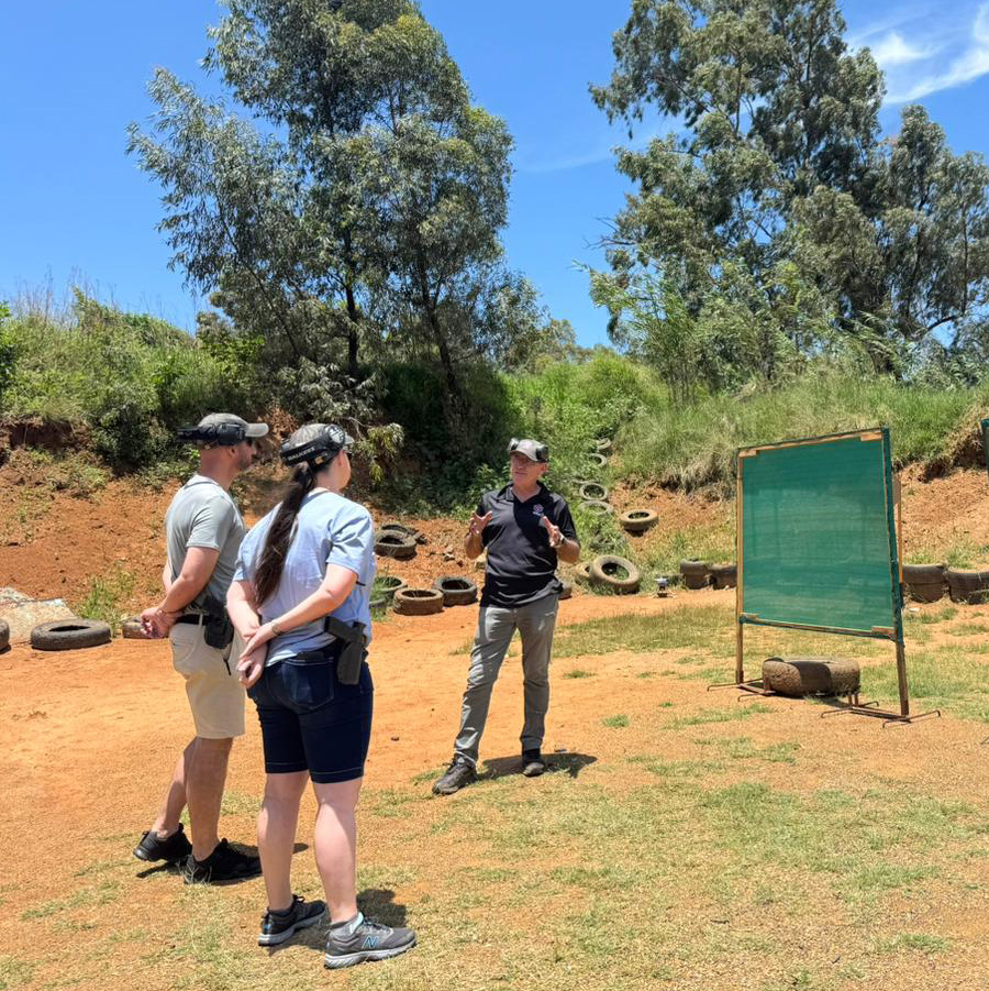 A shield Tactical Instructor explain a shooting concept to two students