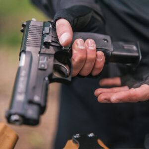 A close up image of a handgun with a magazine being inserted