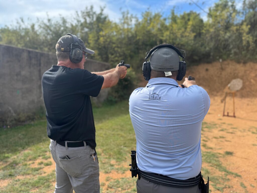 A Shooting Instructor demonstrating grip and sight alignment to a student