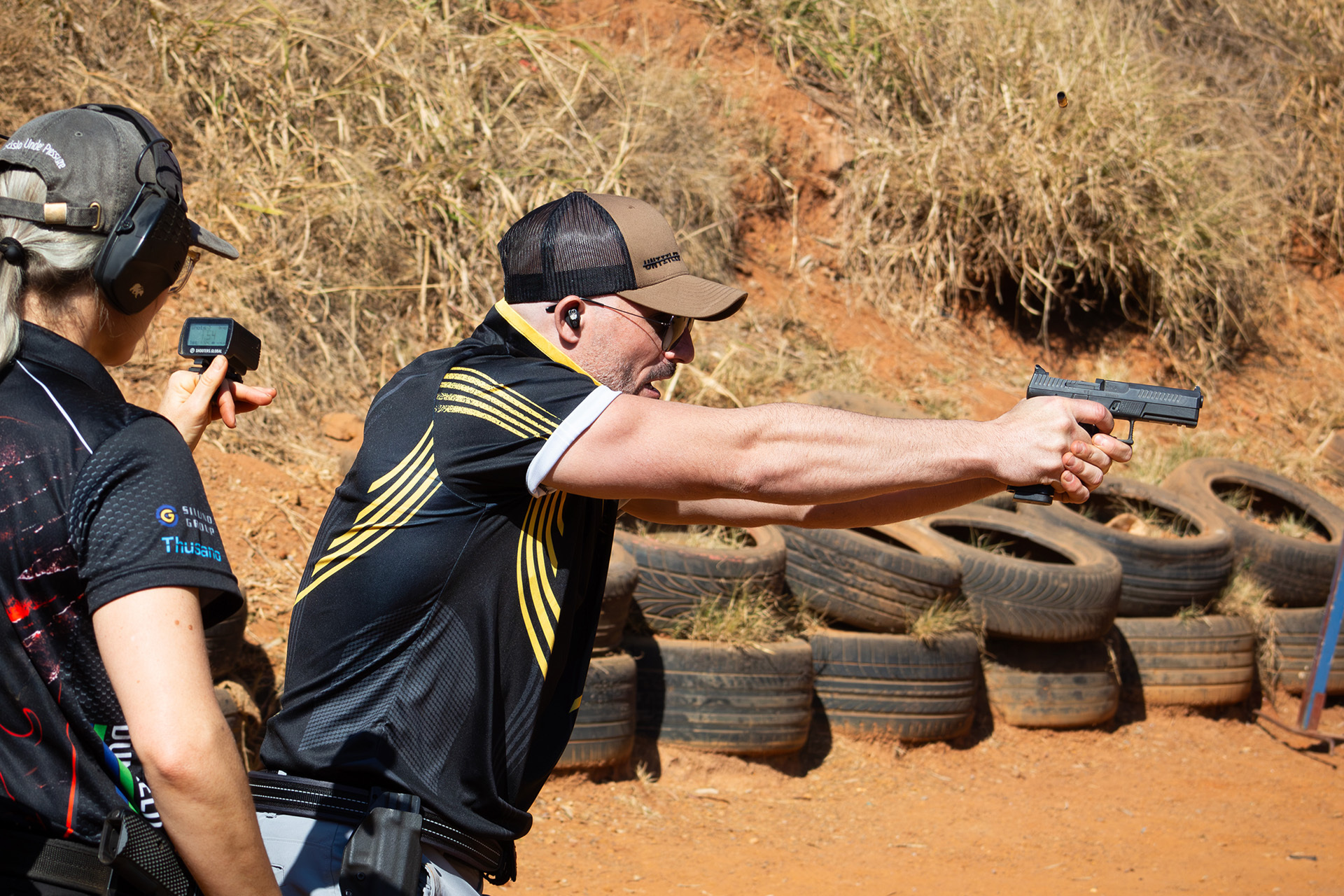 A Range officel looking on as a sport shooter completes a course of fire.